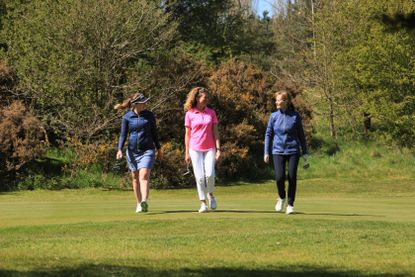Three women golfers on fairway