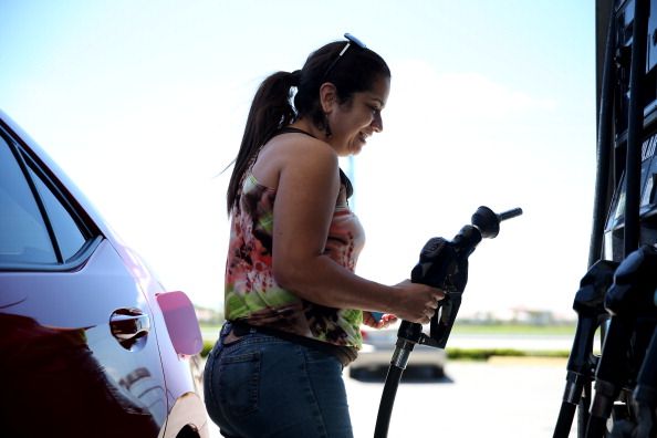 A woman fills up her gas tank.