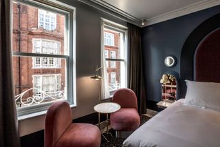 A pale blue room with powder pink seating at Henrietta Hotel London