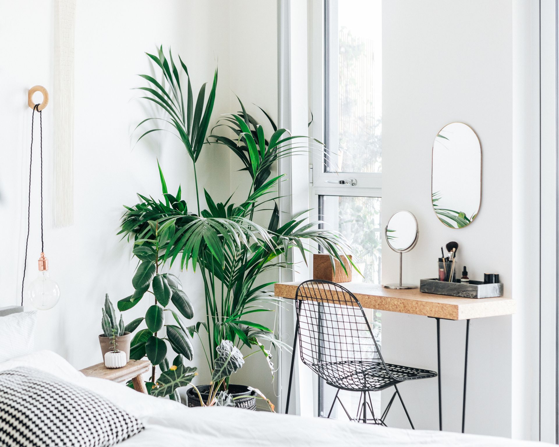 modern stylish white bedroom with plants and dressing table