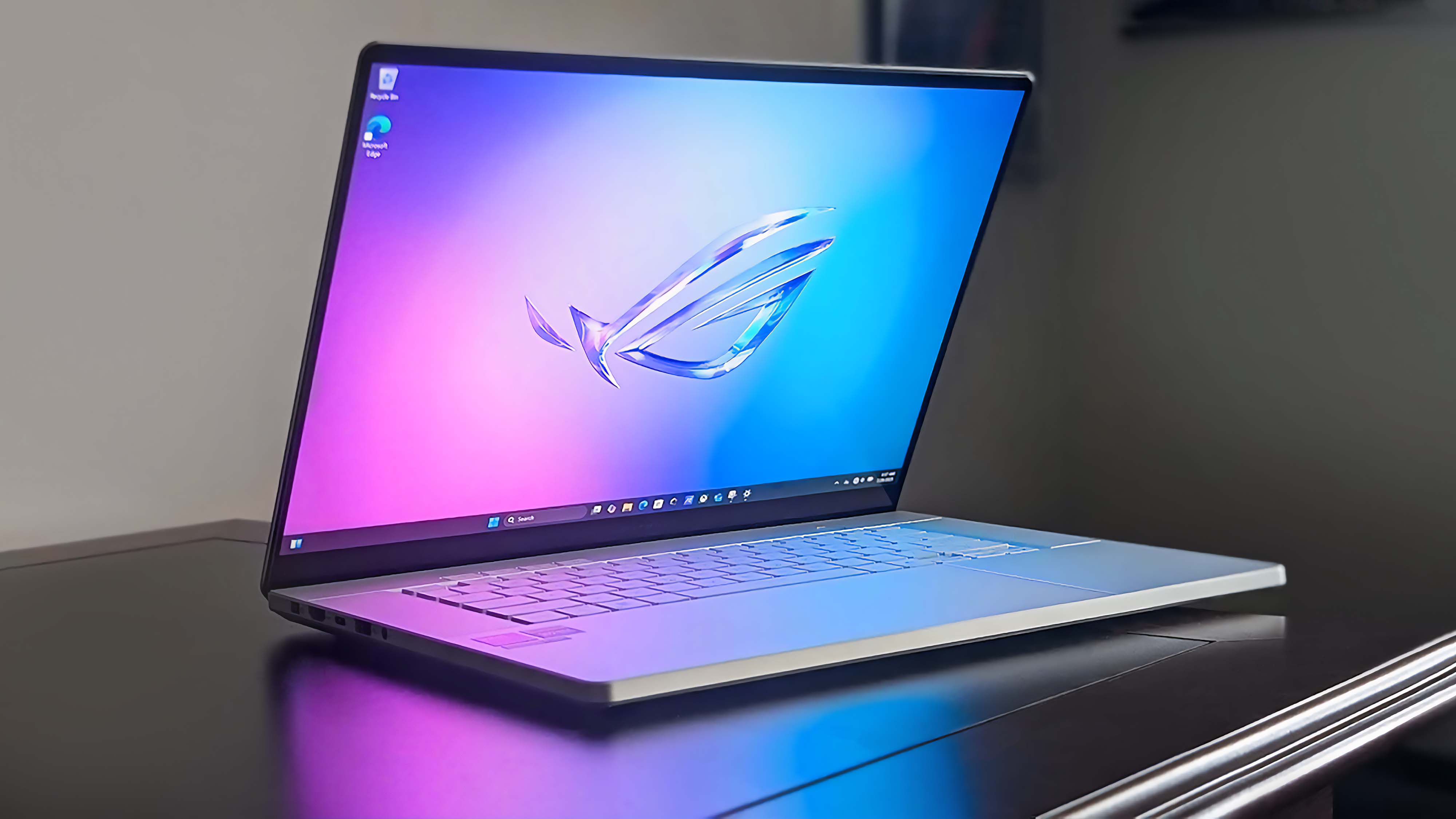 ASUS ROG Zephyrus G16 (GU605C, 2025) sitting on a desk in a dark room.