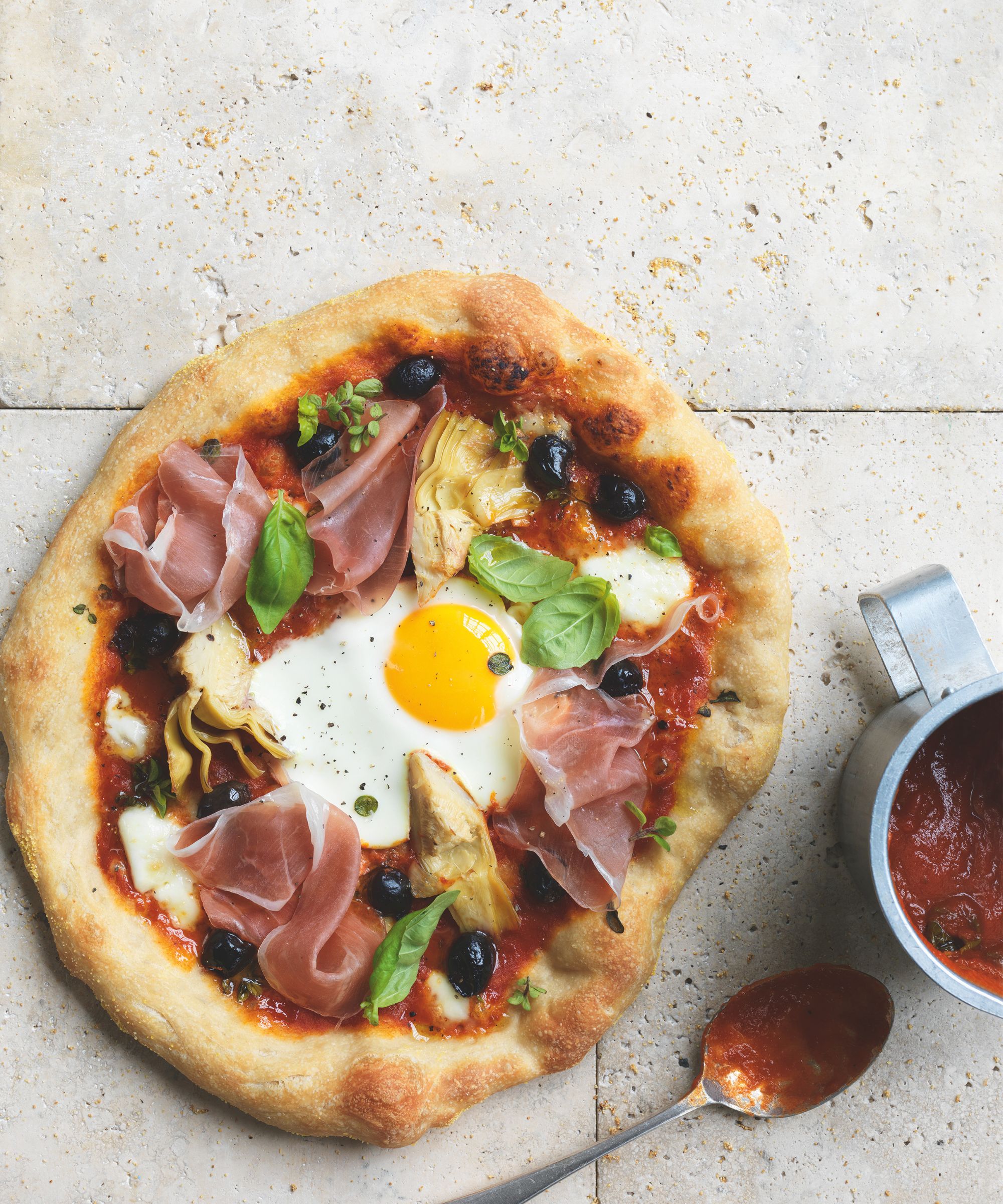 Artichoke, olive and Parma ham pizza with an egg on top