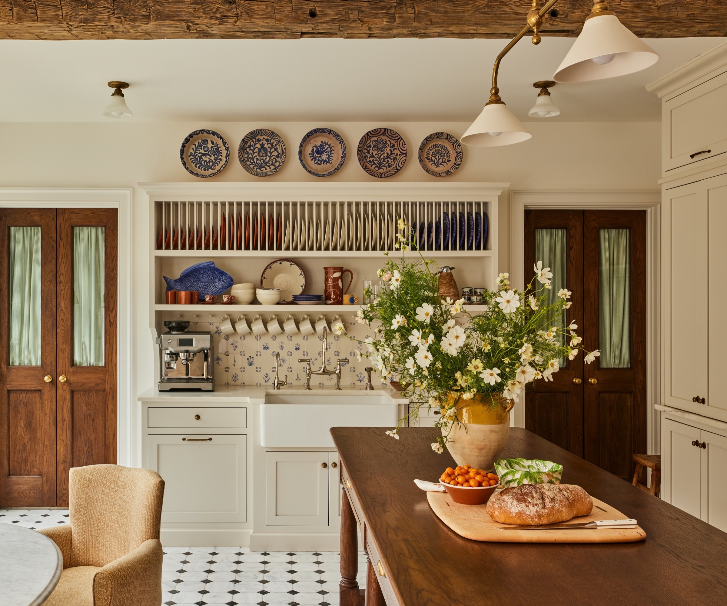 A warm neutral kitchen with a custom hutch with plate racks and a coffee station