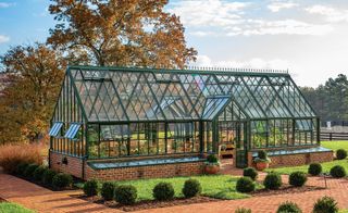 Brick and glass greenhouse with green frame