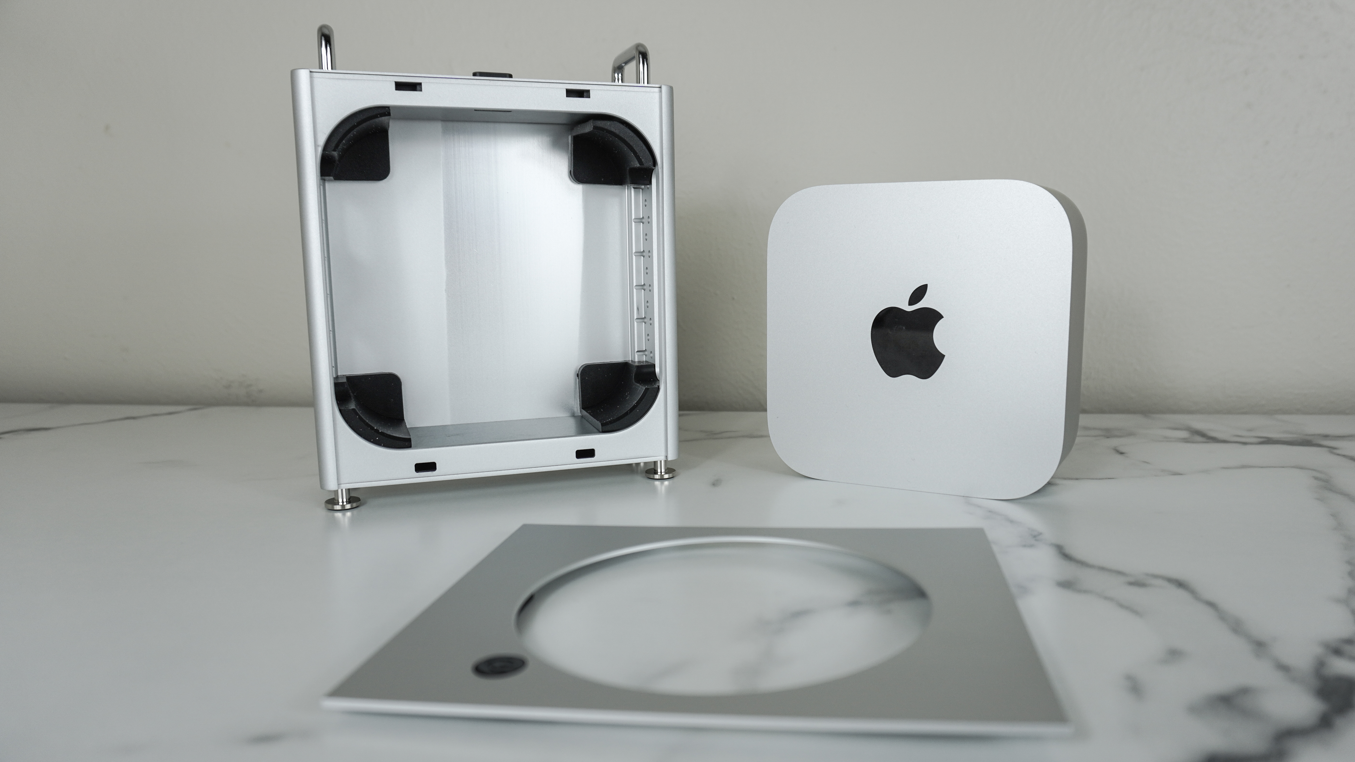 A Mac mini M4 next to the Orico MiniPro Dock Case with its lid off on a desk