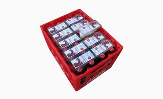 Filled red crate of coca cola photographed from above against a white background