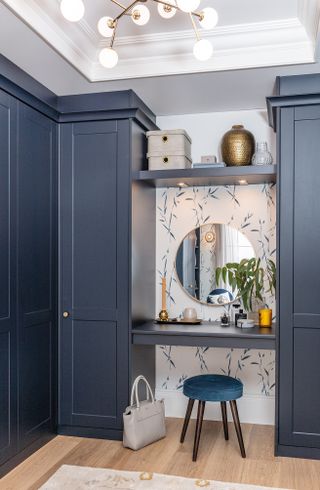 Walk-in closet with blue finish and built in dressing table and stool