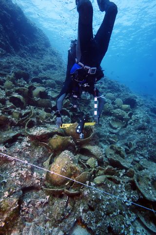 An archaeologist prepares a level on one of the wrecks.