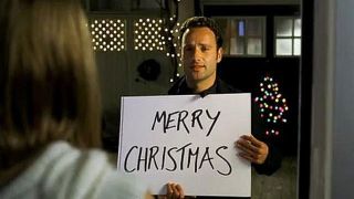 Mark (Andrew Lincoln) from Love Actually holding up Merry Christmas sign