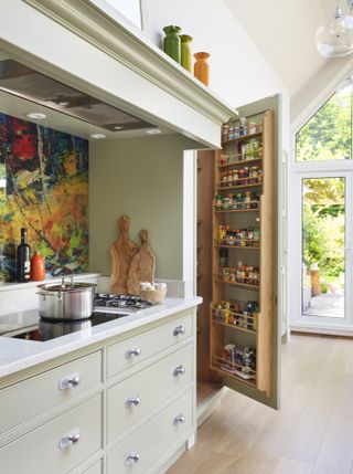 kitchen with cabinet open door showing spice rack on inside of open cupboard door