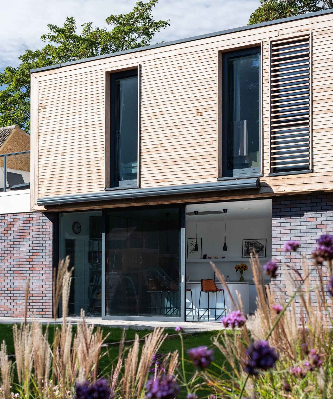 The exterior of a two-storey contemporary self-build home with brick and timber cladding