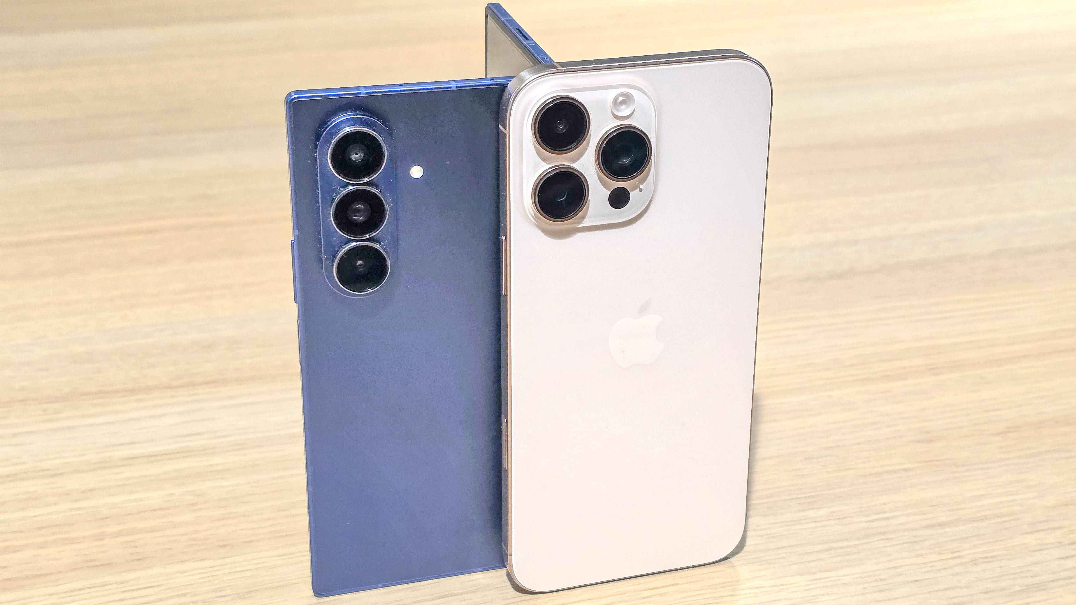 Samsung Galaxy Z Fold 7 and iPhone 16 Pro Max stood together on a table