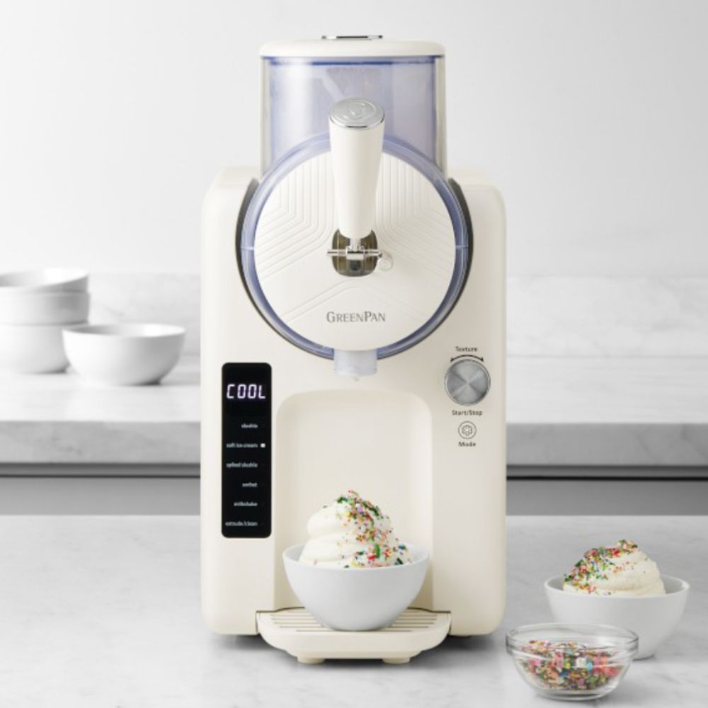 GreenPan Frost ice cream maker in cream on a kitchen counter with a bowl of ice cream