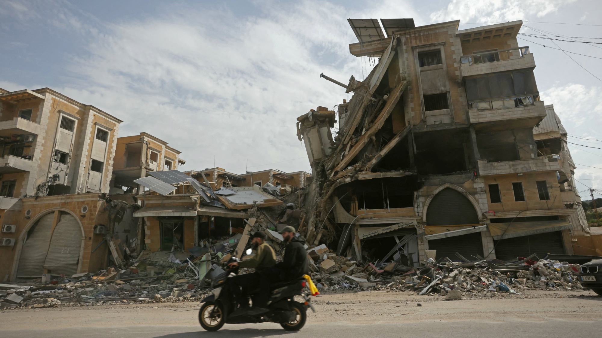 Motorcycle rides past ruins in southern Lebanon after 10-day Israeli ceasefire starts