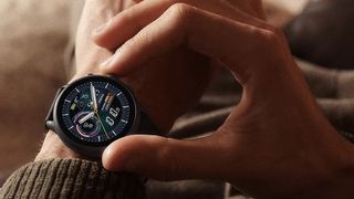 Fossil Gen 6 Wear OS watch worn on left wrist with user preparing to press a button