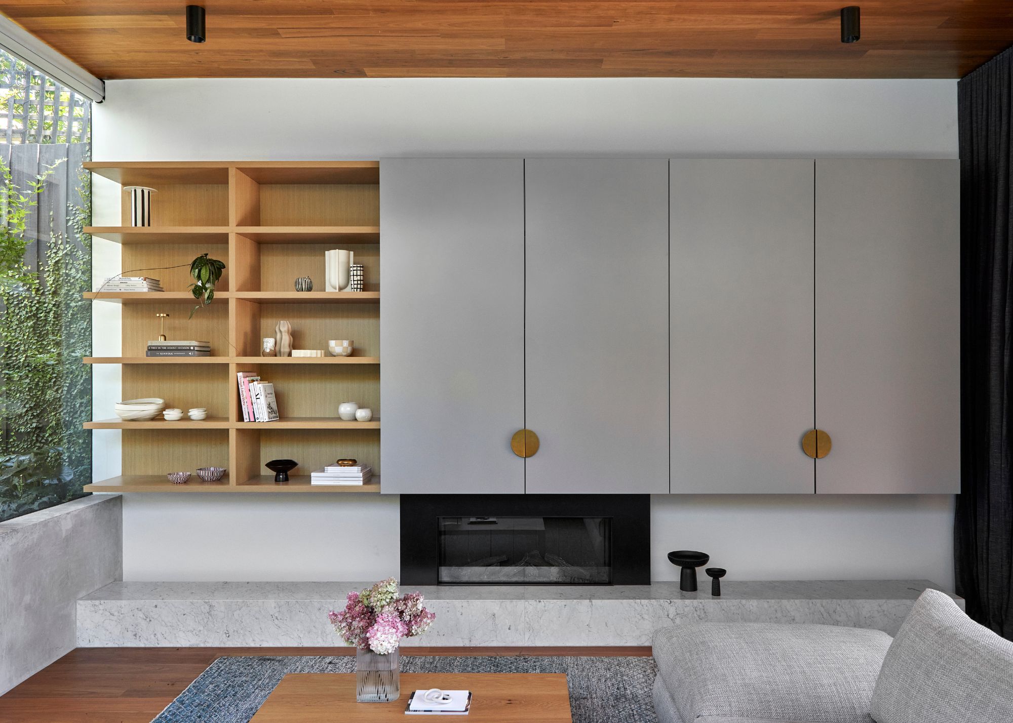 A living room with a grey TV unit, and storage next to it