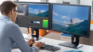 A man at work in front of two monitors