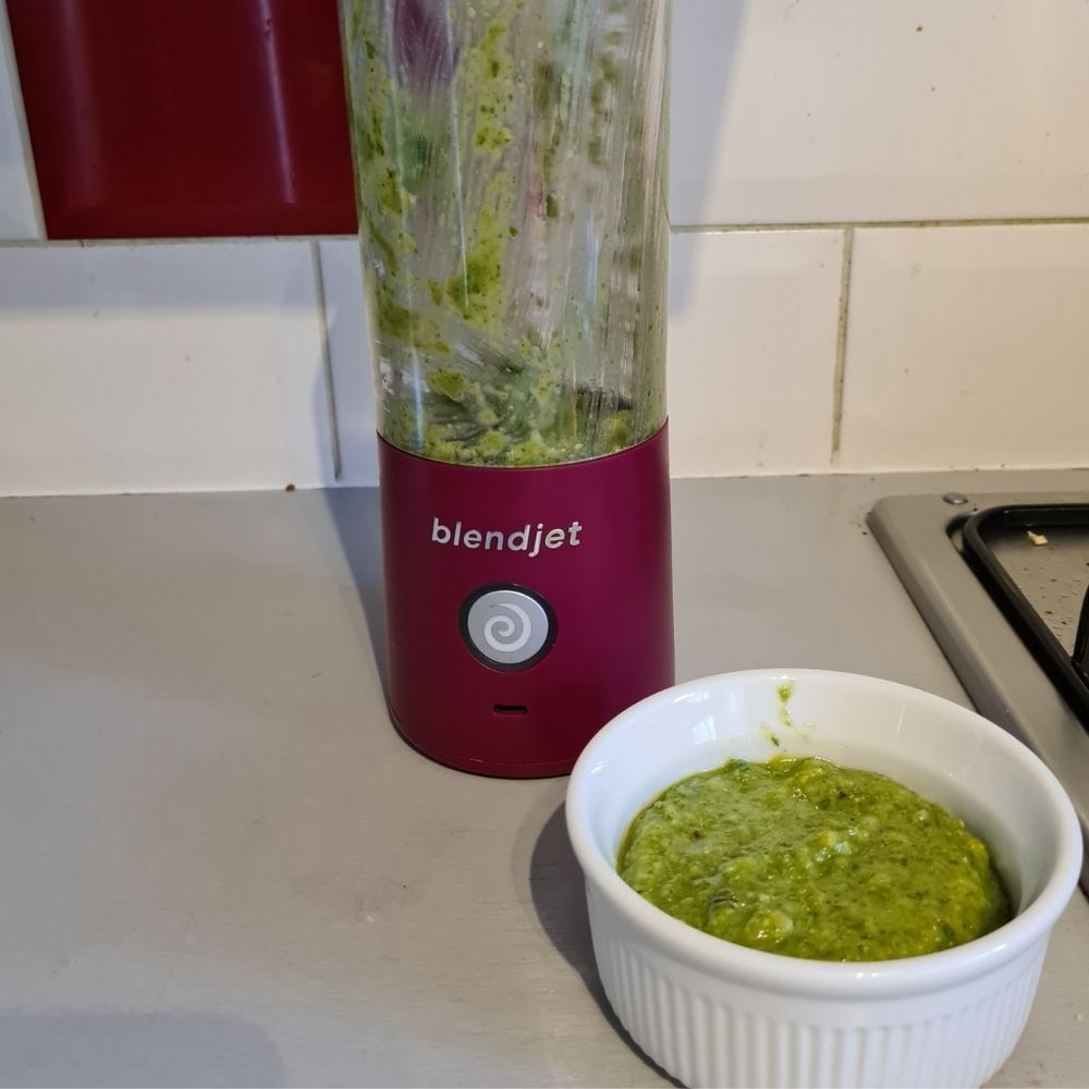 BlendJet 2 beside a white ramekin of green sauce.