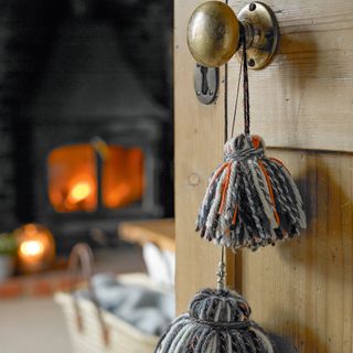 Brass doorknob on wooden door with wool hanging