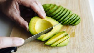 Avocado being sliced with knife