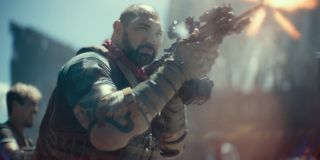 Dave Bautista firing his rifle on the Las Vegas strip in Army of the Dead.