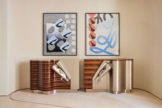 Two collage artworks on the wall above two metal and wood consoles by Maria Pergay