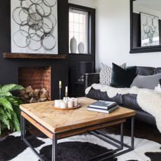 Black and white themed living room with oak accents and logs in fireplace