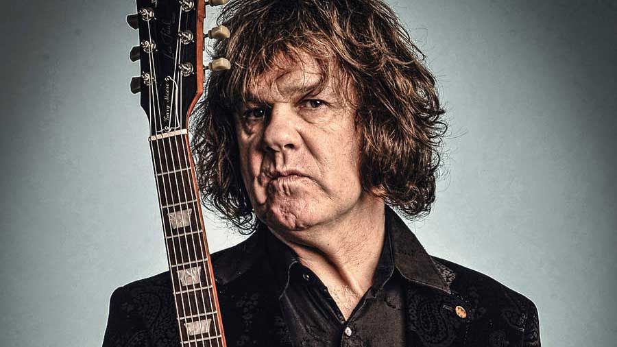 Gary Moore holding a Les Paul guitar - studio portrait