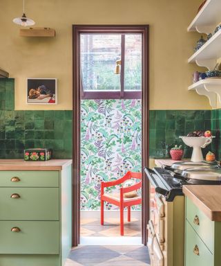 green tiled kitchen through to hallway with pattern on walls