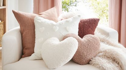 Pink and white heart shaped pillows on neutral chair
