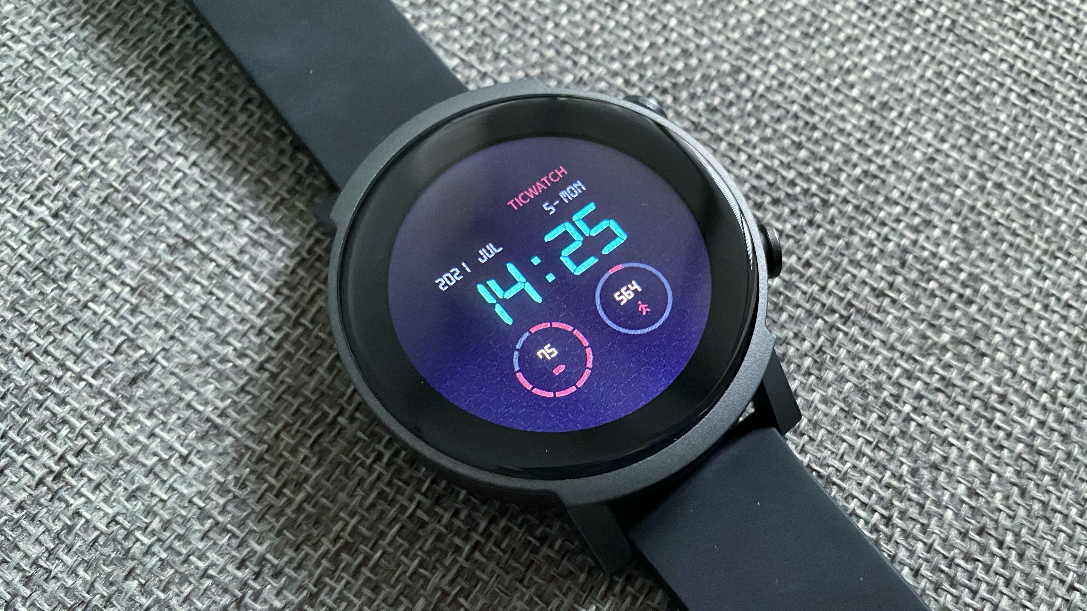 TicWatch E3 lying on a table, with a digital-style watch face