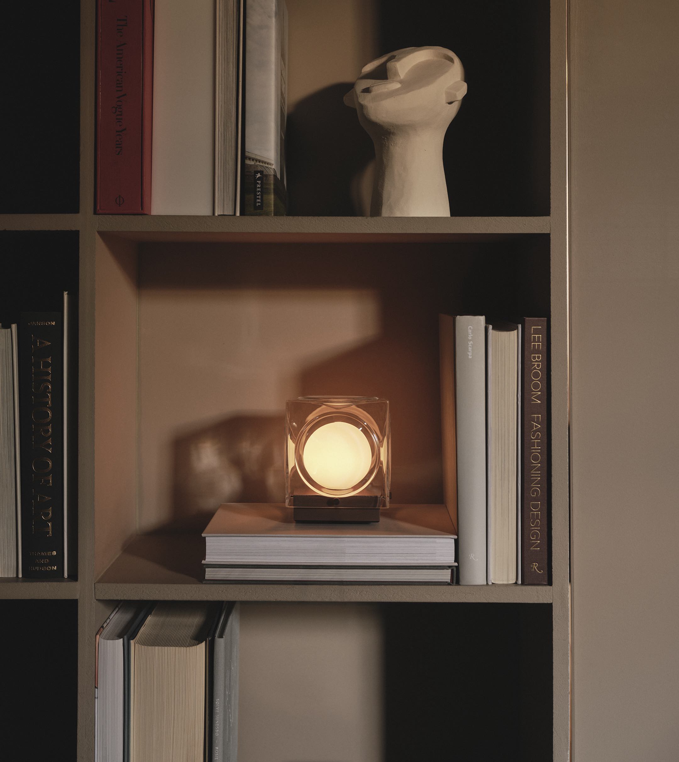 cube shaped glass lamp on bookshelf