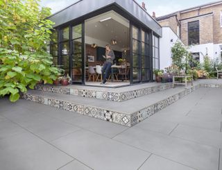 patio with decorative tiles used as the risers for the garden steps