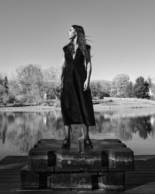 Zosia Mamet stands near a lake