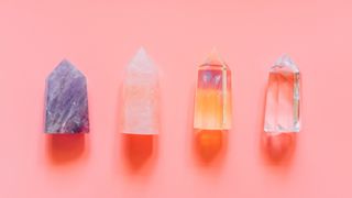 four crystals in a row on a pink background