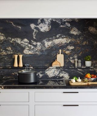 Grey kitchen with grey marble backsplash, worktop and cabinets