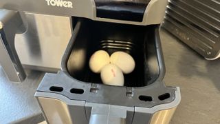 Tre stycken ägg ligger i en behållare till en airfryer.