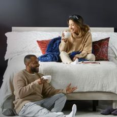 A couple sitting on a Mattress firm bed