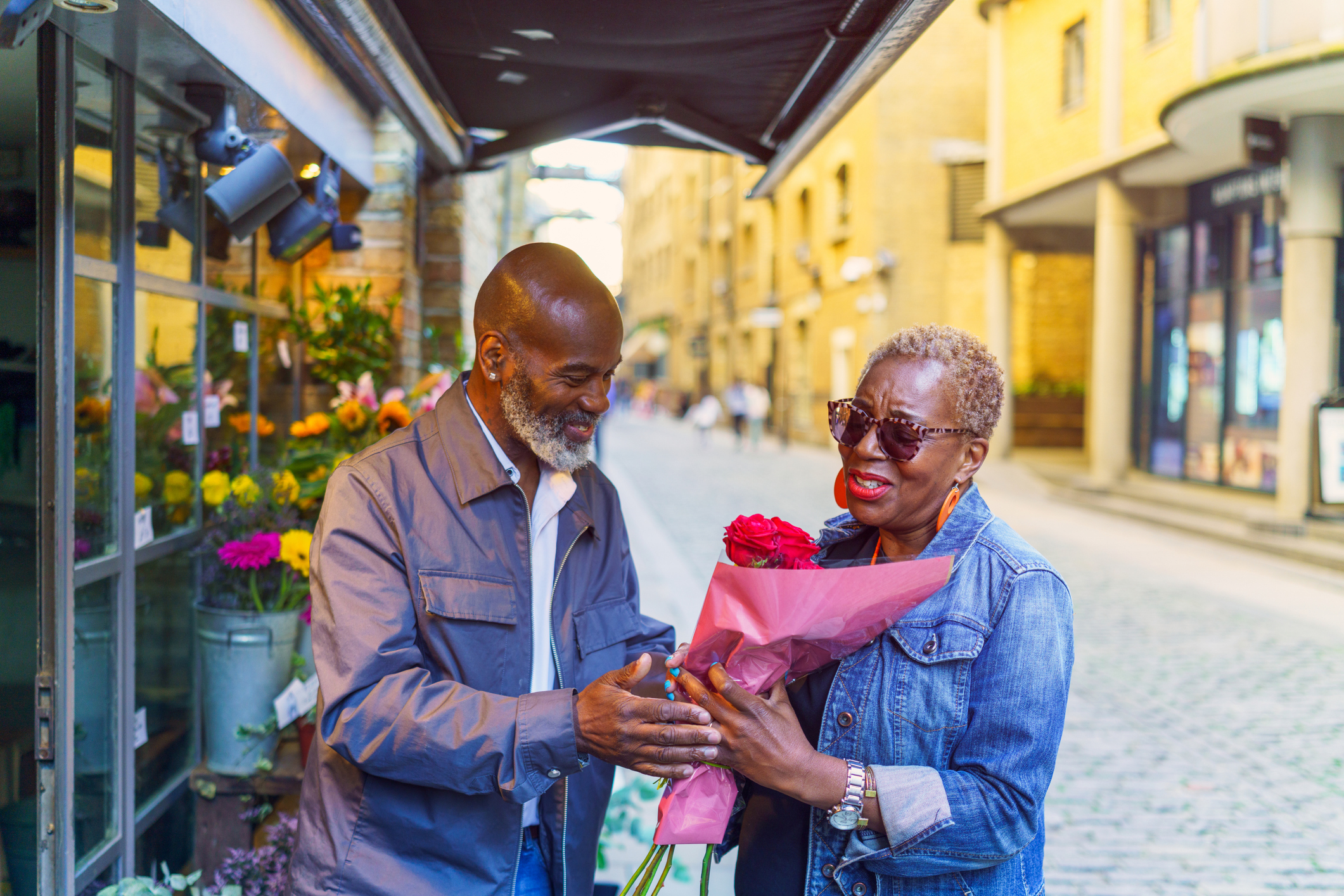 A mature man buying flowers for his partner at a flower stall.