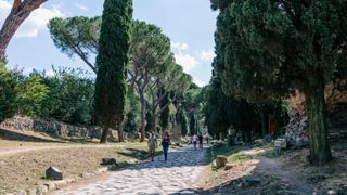 Tourists walking along the Appian Way, a historical road and tourist attraction in Rome, Italy