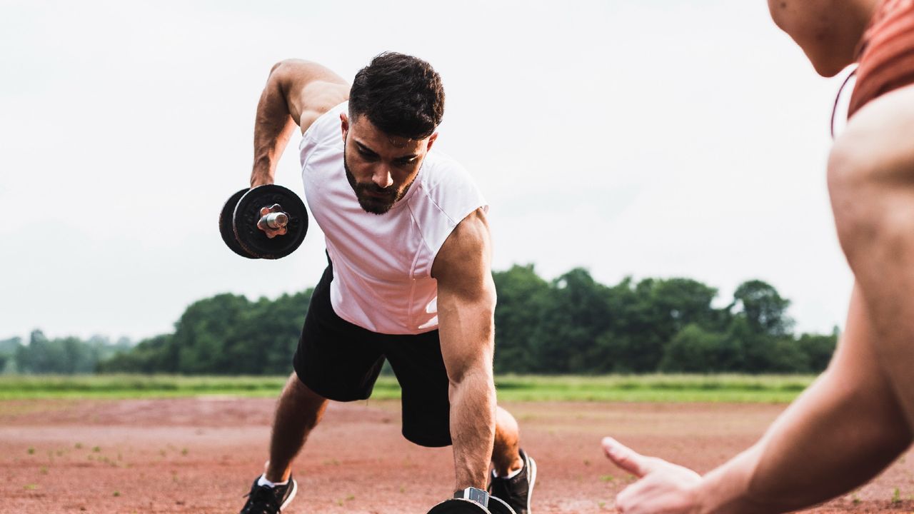 Man completing dumbbell renegade rows