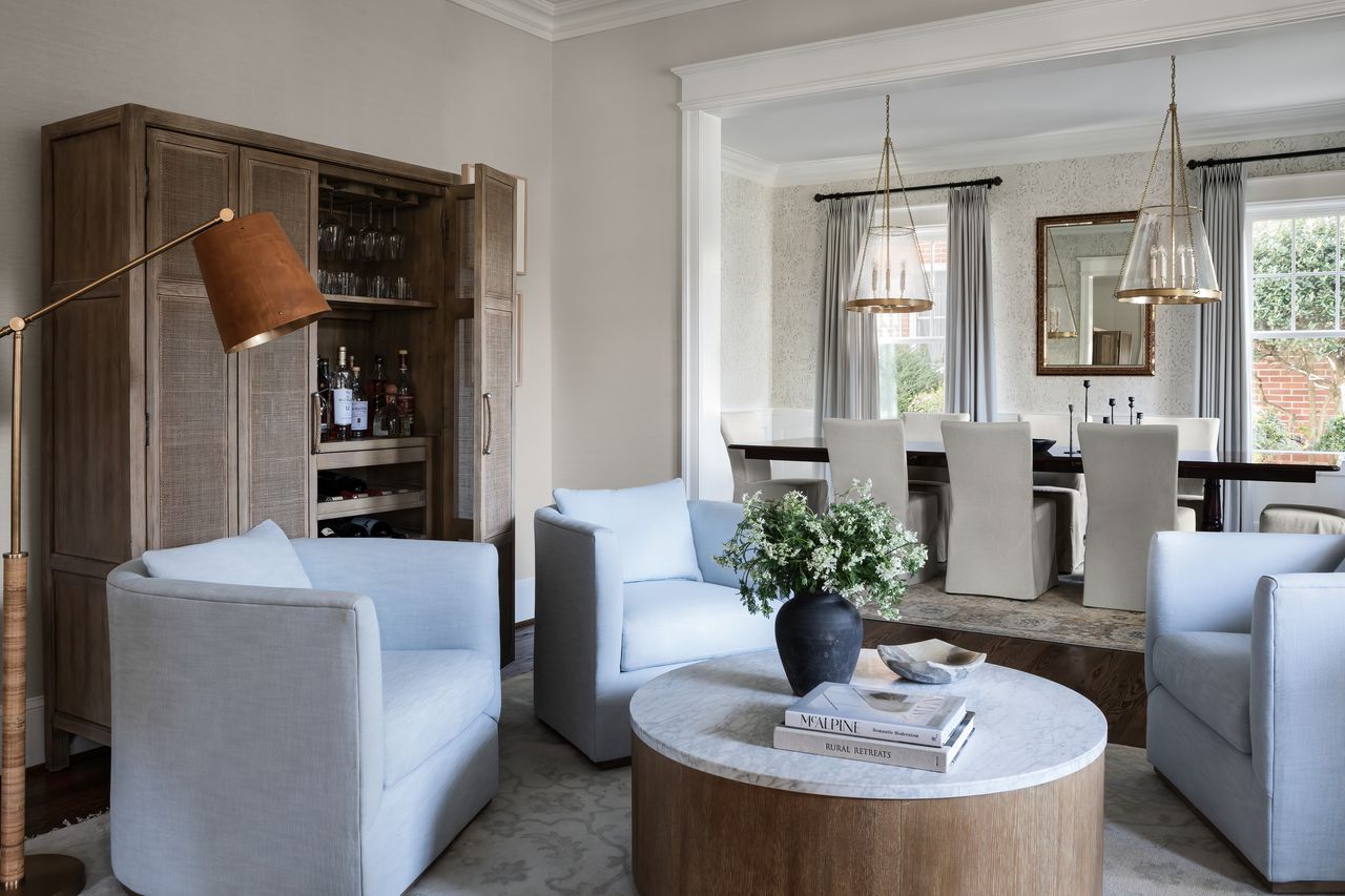 An open plan sitting room with a round fluted table 