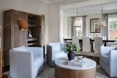 An open plan sitting room with a round fluted table 