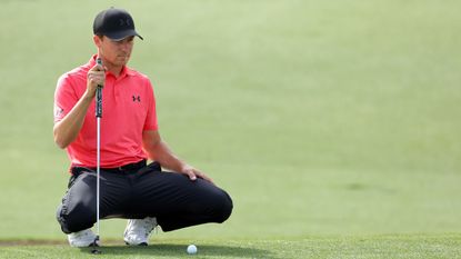 Jordan Spieth crouches behind a putt on day one of the 2024 Masters 