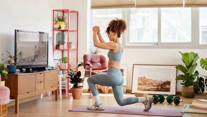 Woman doing a lunge on yoga mat at home