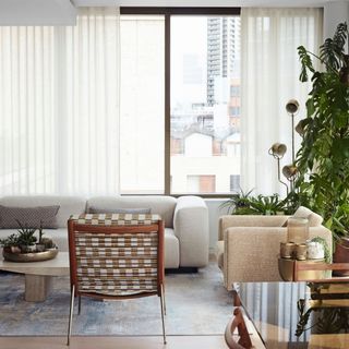 Neutral coloured living room with patterned arm chair and houseplant