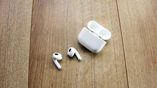 Apple AirPods 3 bredvid laddningsetuiet