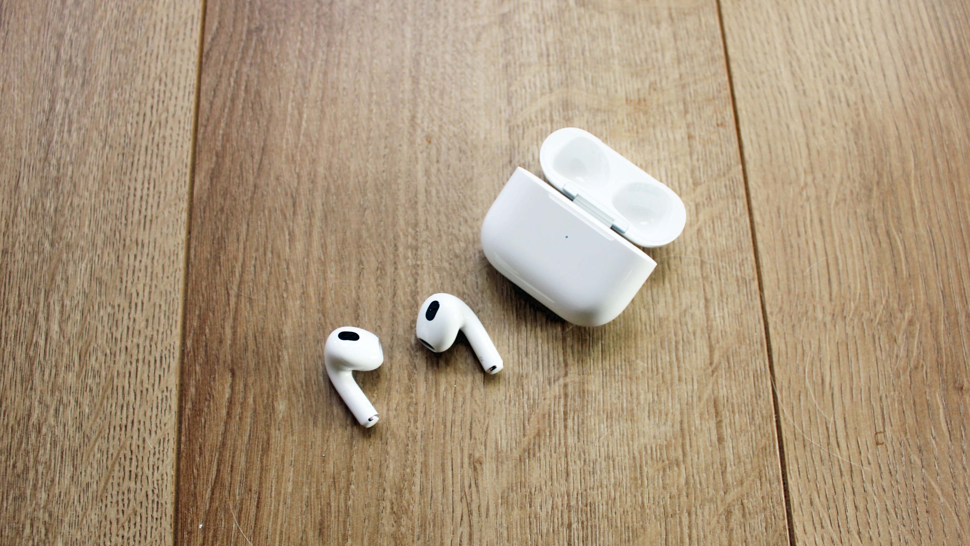 the apple airpods 3 next to their charging case