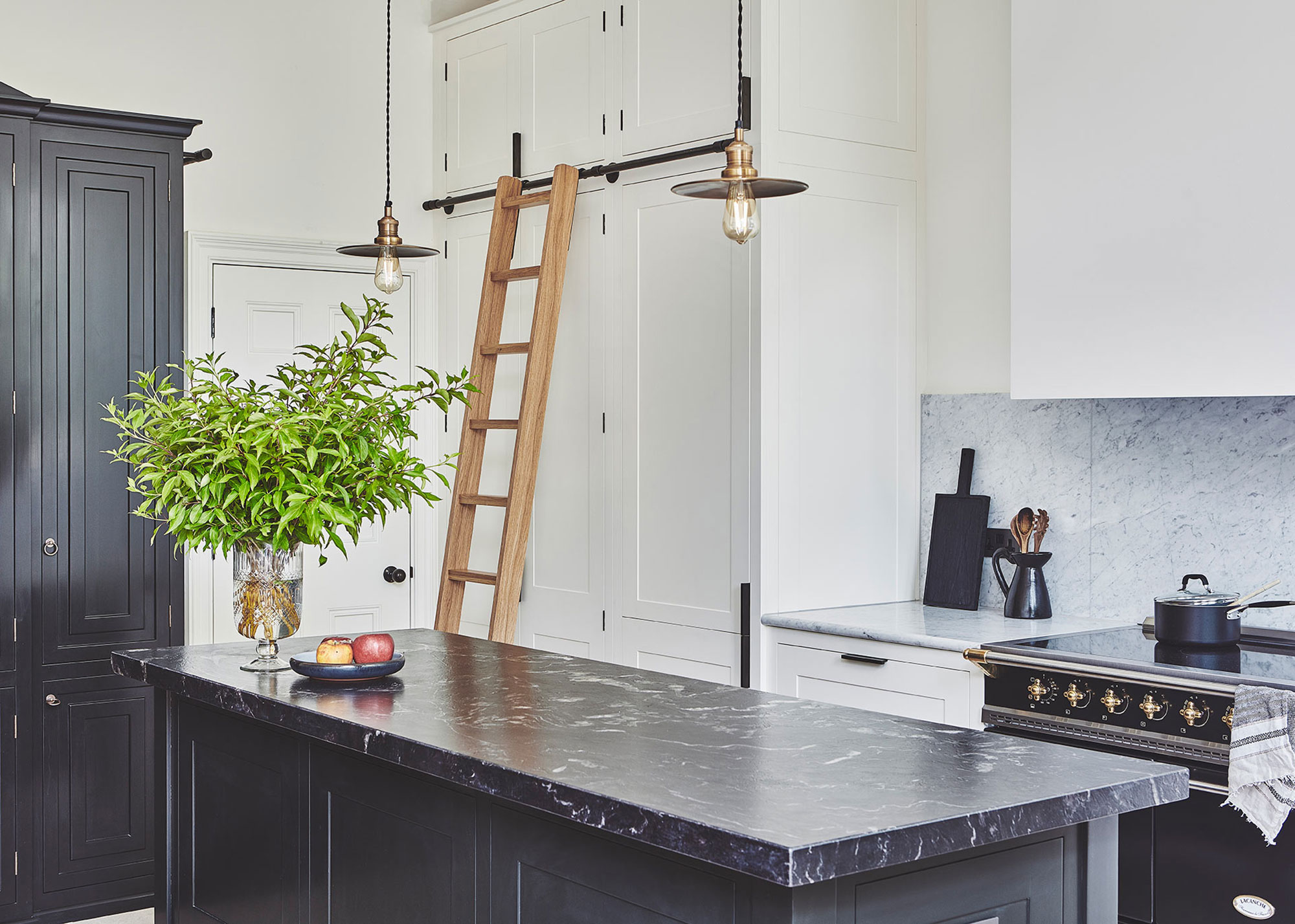 black and white kitchen with high level storage and wooden ladder