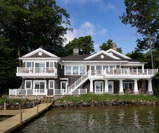 exterior of lakeside home with white pillars and external steps